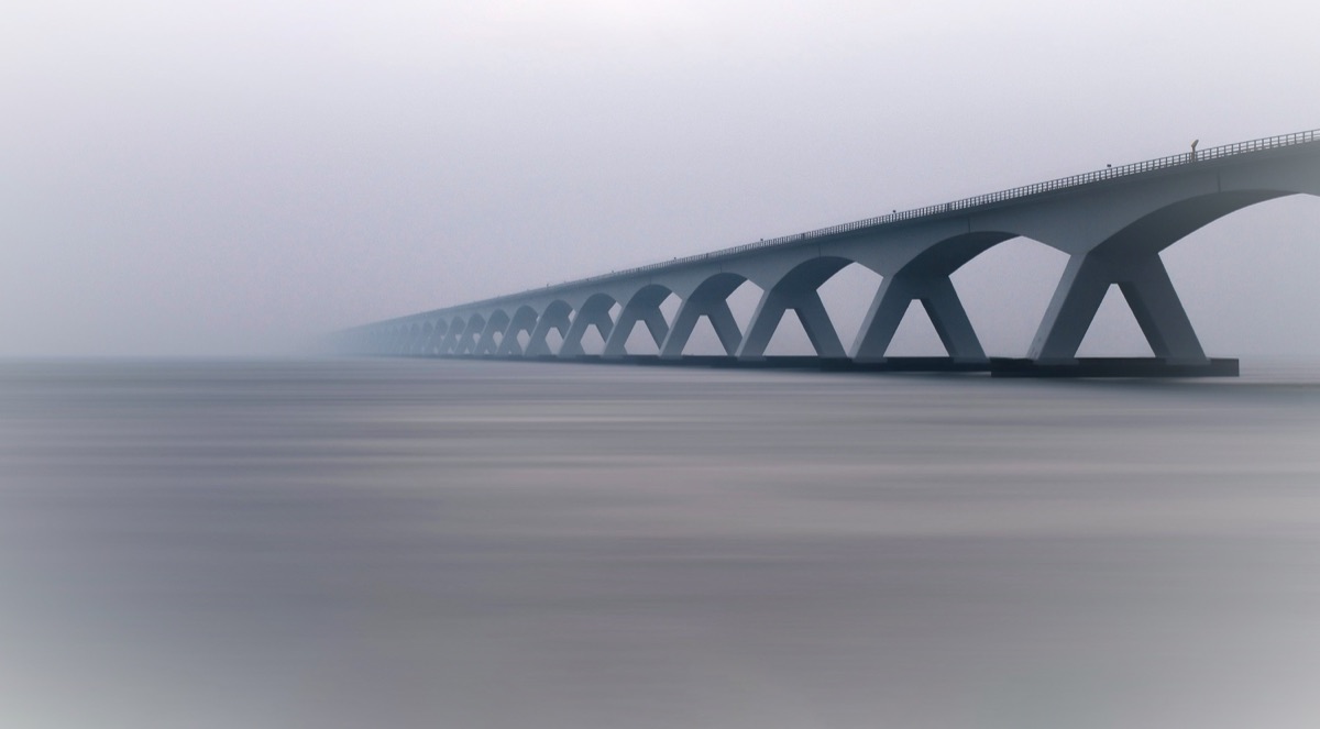 Modern bridge disappearing into fog